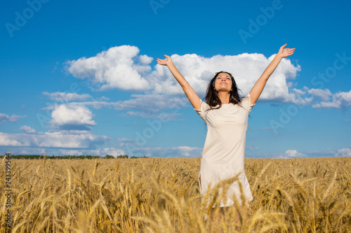 Young woman on a background of golden wheat field