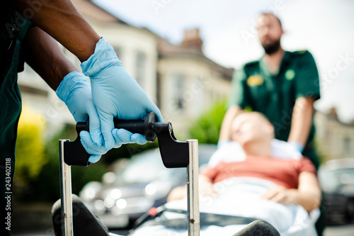 Paramedics moving a patient on a stretcher to an ambulance