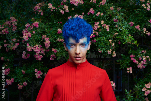 Portrait of a fashionable young guy in a tap-suit and a colorful blue hairstyle