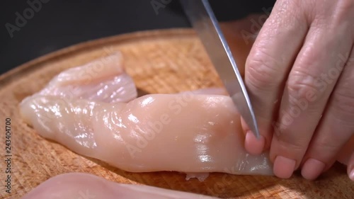 The cook cuts with a knife chicken fillet photo