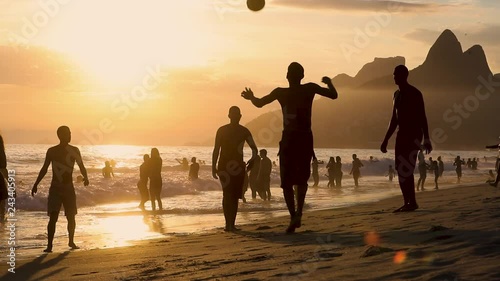 Joung man playing soccer, football on sand beach in Leblon, Copacabana, Rio de Janeiro, Brasil photo