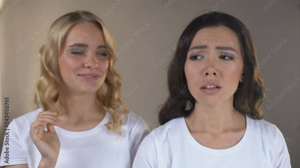 Woman enjoying reflection in mirror, her friend noticing first wrinkles, beauty Woman enjoying reflection in mirror, her friend noticing first wrinkles, beauty