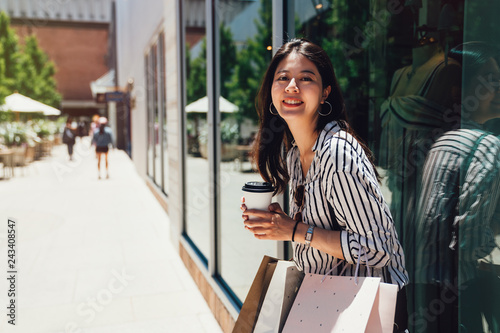 charming girl smiling standing against window photo
