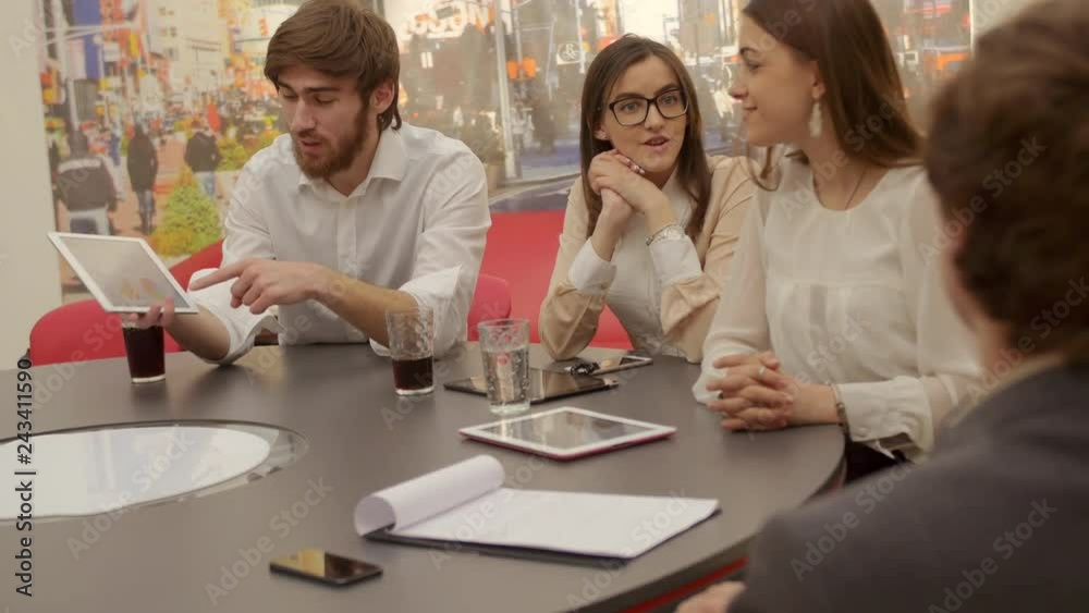 Group of business people using tablet, laptop computer and notebook on meeting. Confident and attractive young business team are working, discussing ideas in a light, modern office building. Group of business people using tablet, laptop computer and notebook on meeting. Confident and attractive young business team are working, discussing ideas in a light, modern office building.