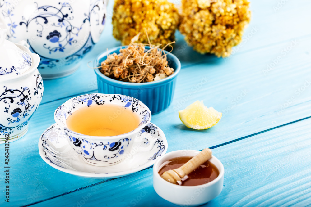 Cup of Linden Tea, Dried Linden Flowers in bowl with honey and lemon on wooden background Cup of Linden Tea, Dried Linden Flowers in bowl with honey and lemon on wooden background