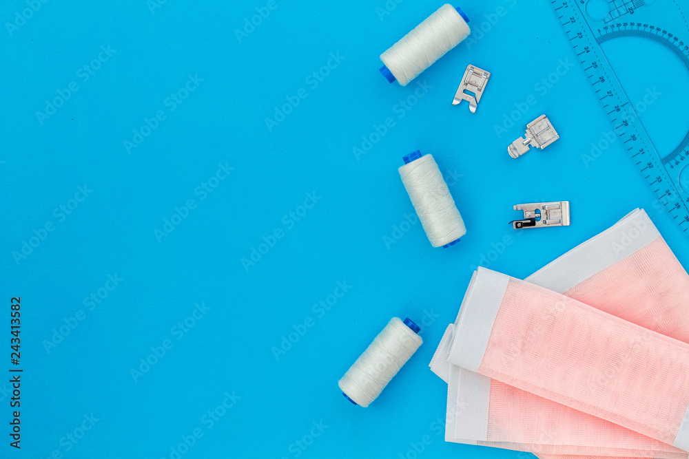 Woman hobby. Set for tailor shop with thread, fabric on blue background top view copy space Woman hobby. Set for tailor shop with thread, fabric on blue background top view copy space