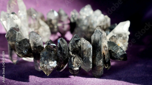 Fotografi Black phantom quartz bracelet on violet background with space for write wording,