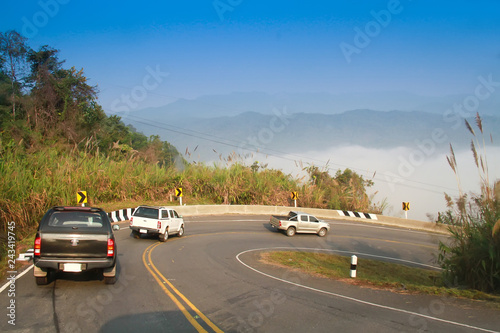 driving on curve road in the mountain with the sea mist and blue sky and forest, country road in north of Thailand