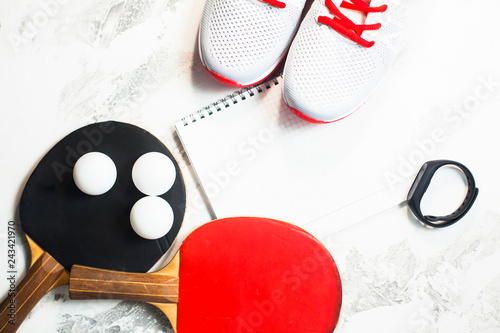 Sport fitness  weight loss concept. Ping pong racket  balls  notepad  sneakers on white wooden background