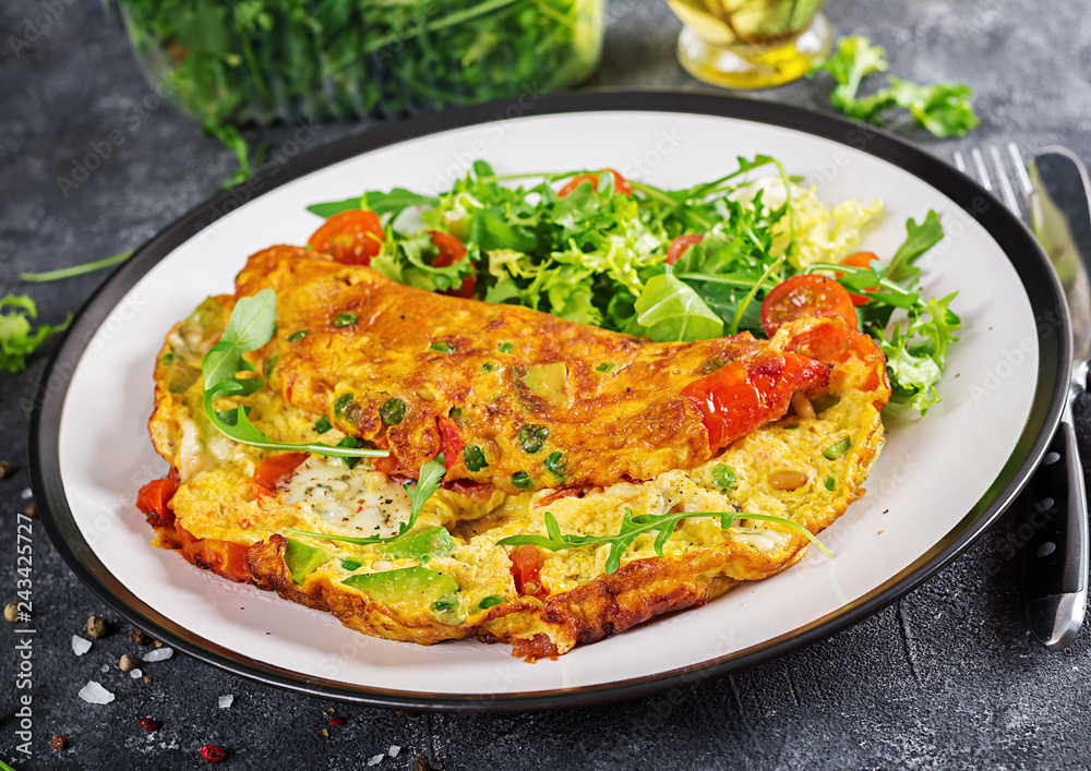 Breakfast. Omelette with tomatoes, avocado, blue cheese and green peas on white plate. Frittata - italian omelet. Breakfast. Omelette with tomatoes, avocado, blue cheese and green peas on white plate. Frittata - italian omelet.