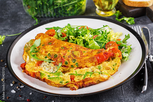 Breakfast. Omelette with tomatoes, avocado, blue cheese and green peas on white plate.  Frittata - italian omelet.
