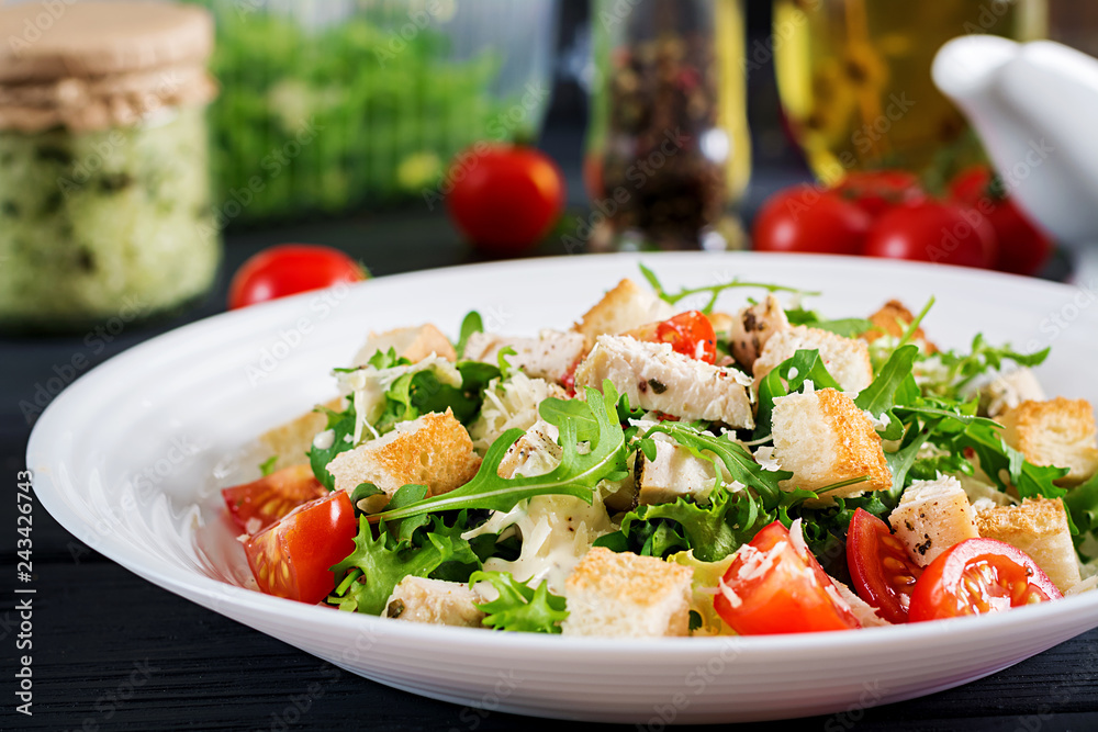 Healthy grilled chicken Caesar salad with tomatoes, cheese and croutons. North American cuisine. Healthy grilled chicken Caesar salad with tomatoes, cheese and croutons. North American cuisine.