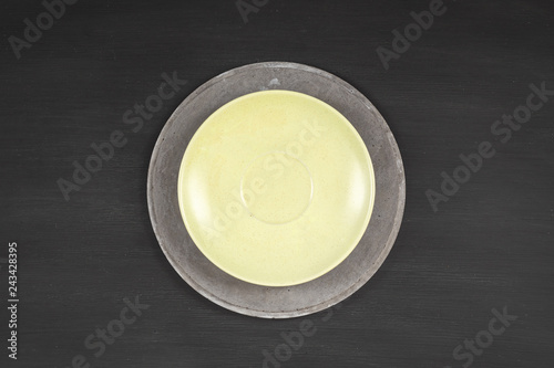 yellow plate on concrete plate on dark background