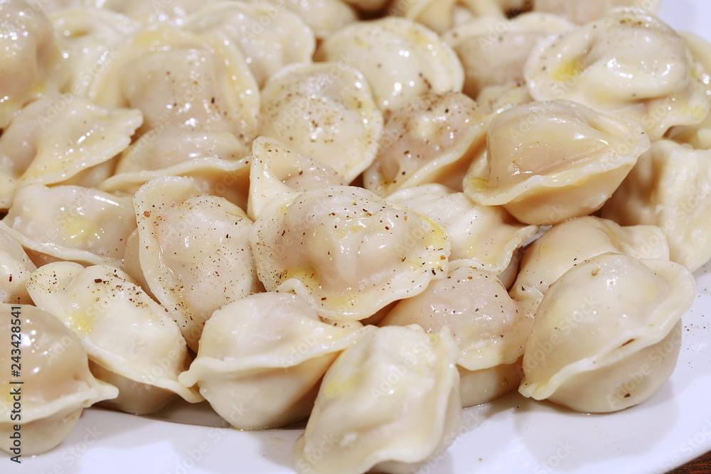 Hot Siberian dumplings with greens on a white plate Hot Siberian dumplings with greens on a white plate