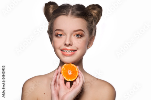 Healthy, beautiful smile, cute teen  with dental braces smiling . Portrait of a girl with orthodontic appliance and tangerine . photo