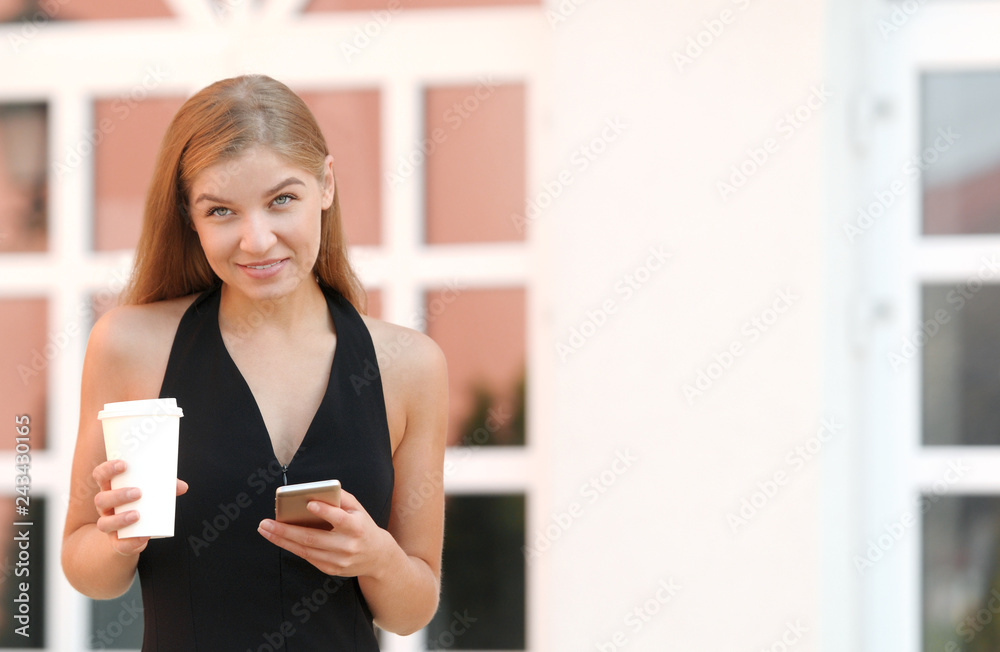 Businesswoman talking via mobile phone and holding a coffee cup against urban scene. Businesswoman talking via mobile phone and holding a coffee cup against urban scene.