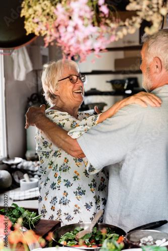 Cheerful senior couple hugging in the kitchen