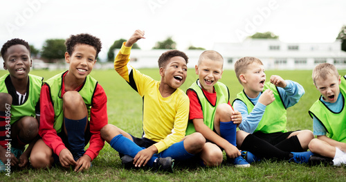 Enthusiastic football players sitting on the field