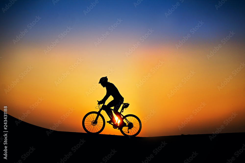 Fototapeta premium Silhouette of cyclist with mountain bike on beautiful sunset time.