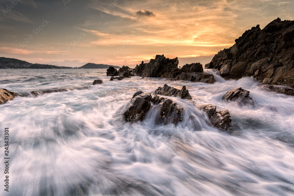 Fototapeta premium Beautiful seascape with wave and rock at sunset