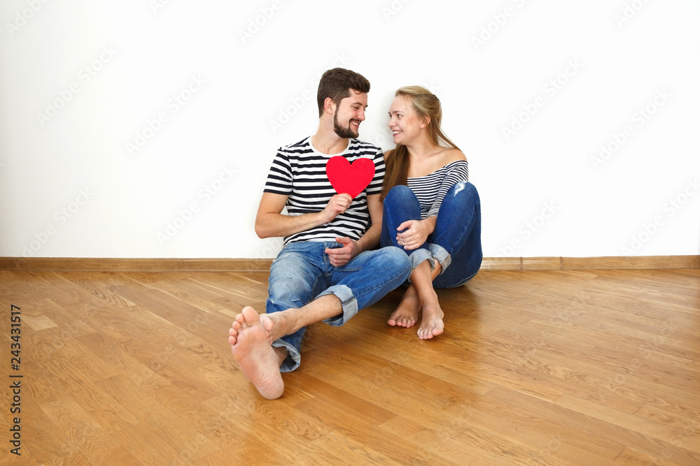 Happy young couple in love sitting on the floor in their apartment. Happy young couple in love sitting on the floor in their apartment.