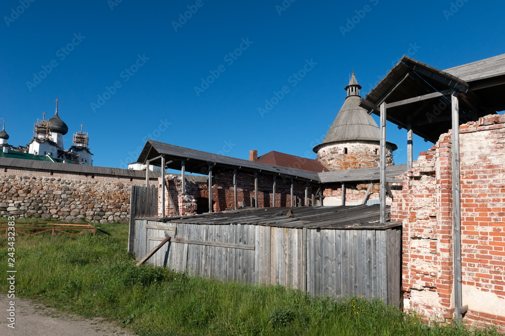 Spaso-Preobrazhensky Solovetsky Monastery and the ruins of a power station building in the summer day, Russia