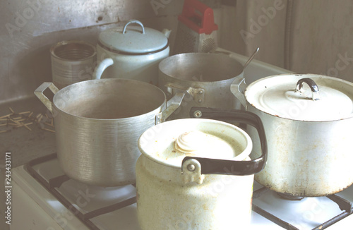 old dishes, kettle, pans on the gas burner