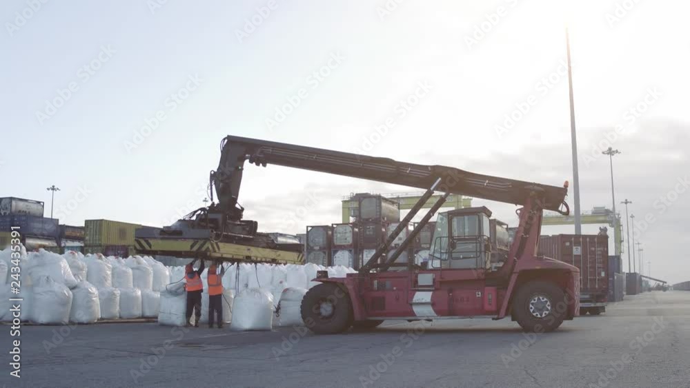 Crane operator and Mobile crane machine stand by waiting for lifting white bags in the dock. Crane operator and Mobile crane machine stand by waiting for lifting white bags in the dock.