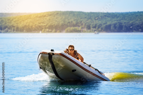 Inflatable rubber boat with captain on the water or lake photo