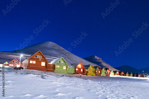 The polar arctic Northern lights aurora borealis sky star in Norway Svalbard in Longyearbyen city the moon mountains © bublik_polina