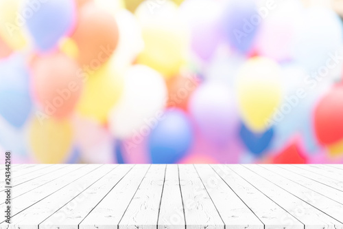 Perspective empty white wooden table on top over blur balloon background, can be used mock up for montage products display or design layout.