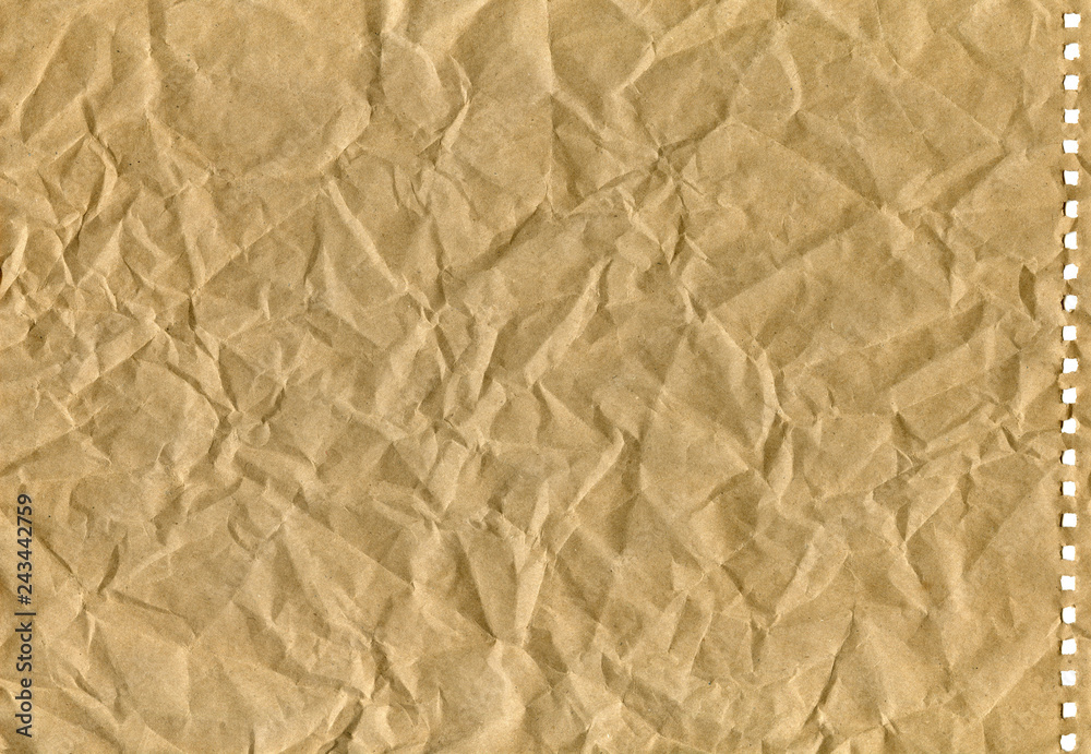 Fototapeta premium brown crumpled old kraft paper with perforation, background