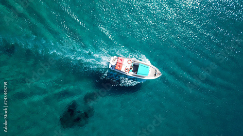 Aerial bird's eye view photo taken by drone of boat cruising in caribbean tropical beach with turquoise - sapphire waters © aerial-drone