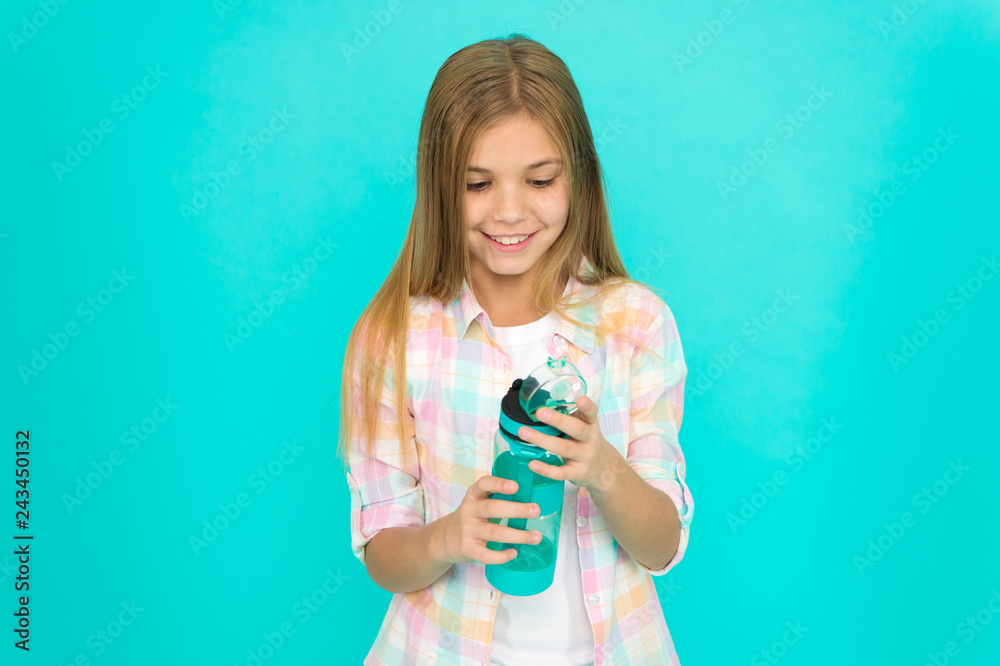 Healthy and hydrated. Pediatric disorders of water balance. Girl cares about health and water balance. Kid hold bottle blue background. Child girl long hair has water bottle. Water balance concept Healthy and hydrated. Pediatric disorders of water balance. Girl cares about health and water balance. Kid hold bottle blue background. Child girl long hair has water bottle. Water balance concept
