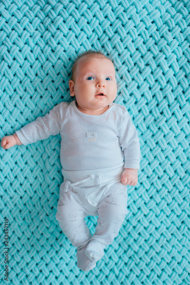 Adorable lovely newborn male baby with blue eyes lifestyle indoor portrait  from above. Cute child with