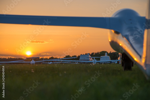 Segelflugzeuge stehen auf einem Flugfeld im Sonnenuntergang