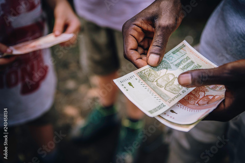 Close up - Händler zählt Geldscheine auf einem Markt in Simbabwe photo