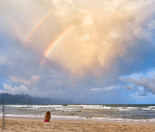 Beautiful woman is enjoy rainbow view at My Khe beach, Da Nang, Vietnam