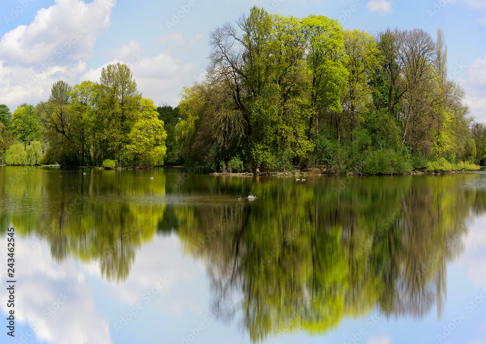 Kleinhesseloher See mit Spiegelung im Frühling, München, Bayern, Deutschland Kleinhesseloher See mit Spiegelung im Frühling, München, Bayern, Deutschland