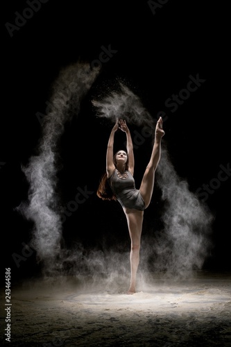 Gorgeous brunette dancing in dust in the dark