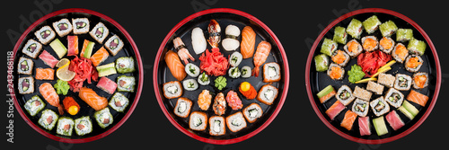 Sushi Set nigiri, rolls and sashimi served in traditional Japan black Sushioke round plate. On dark background