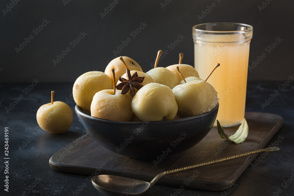 Pickled apples in bowl and apple sidr on dark stone table. - obrazy, fototapety, plakaty 
