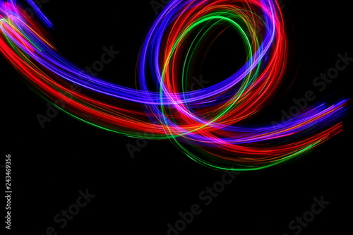 Light painting, long exposure photography, vibrant multi color against a black background