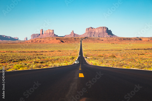 Straight road in Monument Valley at sunset, USA