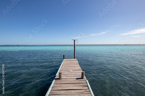 wooden jetty for boats on a blue and blue crystalline Caribbean sea. Caribbean vacation with a dedicated boat dock