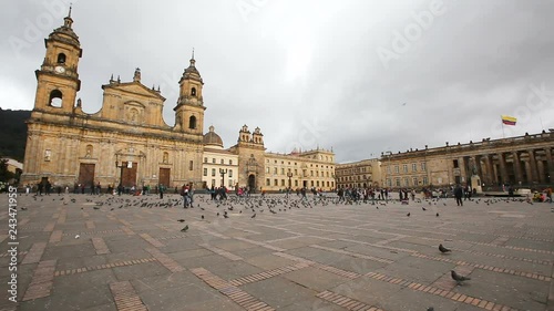 BOGOTA, COLOMBIA - JUNE 14: Unidentified people walk past the Archbishopric Cathedral of Bogota and the Capitolia Nacional in Bogota, Colombia on June 16, 2016. photo