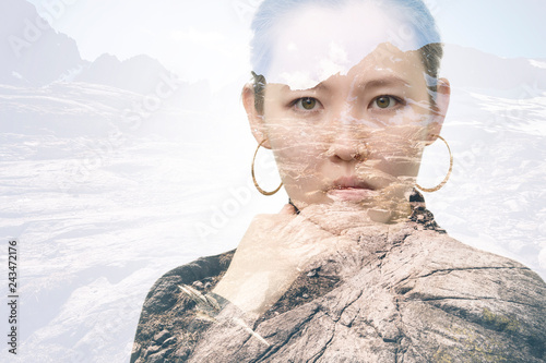 Double exposure portrait of a young Asian woman combined with a photograph of the mountainous landscape