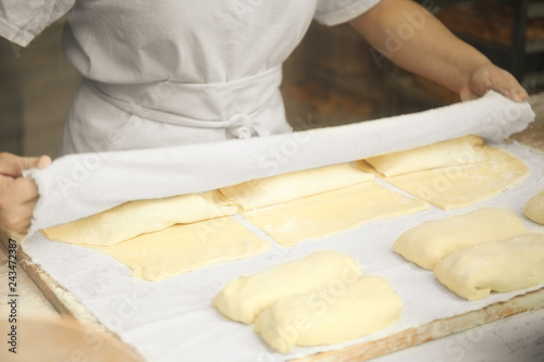Professional chef rolling dough in the kitchen. Commercial bakery.