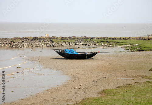 Boats of fishermen stranded in the mud at low tide on the coast of Bay of Bengal, India