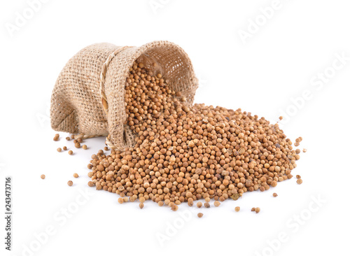 dried coriander seeds in sack and on white background